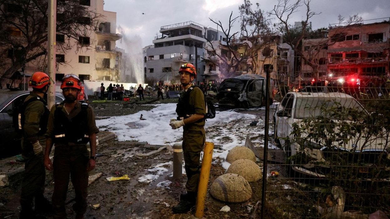Emergency personnel work at an impact site following a missile attack from Iran on Israel, in Tel Aviv, Israel, on June 16, 2025.