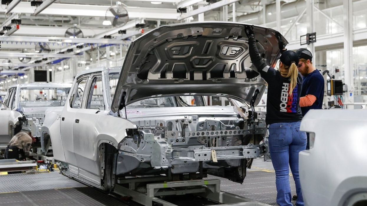Employees work on an assembly line at startup Rivian Automotive's electric vehicle factory in Normal, Illinois, U.S. April 11, 2022.