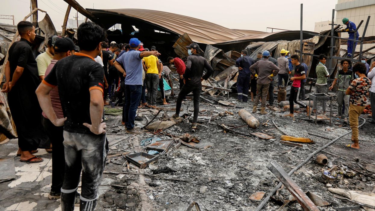 eople gather as they inspect the damage at al-Hussain coronavirus hospital where a fire broke out, in Nassiriya, Iraq, July 13, 2021.