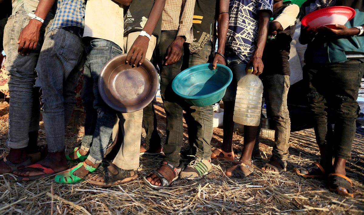 Ethiopian refugees who fled Tigray region, queue to receive food aid within the Um-Rakoba camp in Al-Qadarif state, on the border, in Sudan December 11, 2020.