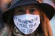 A woman wearing a face mask that says, "if you can read this it means you are too close."