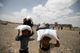 People carry food aid they received on the outskirts of Sanaa, Yemen.