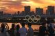 People look at an Olympics rings monument lit up after sunset in Tokyo on July 21, 2021, two days ahead of the Tokyo Olympics opening ceremony.