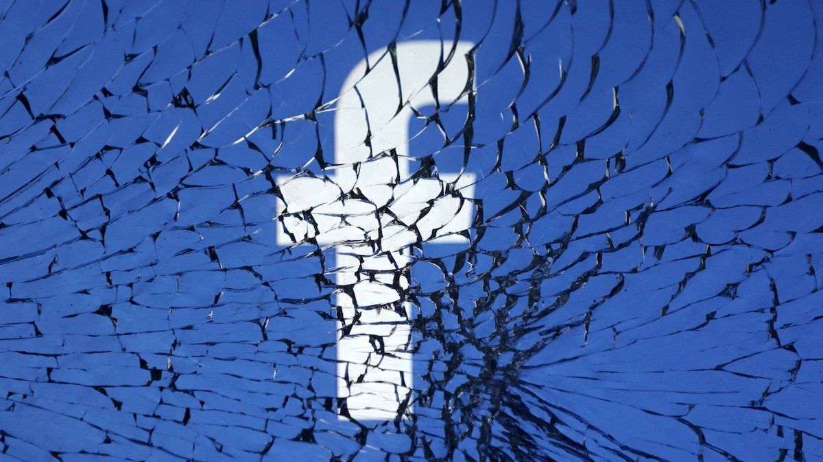 Facebook logo is seen through broken glass in this illustration taken, January 25, 2023. 
