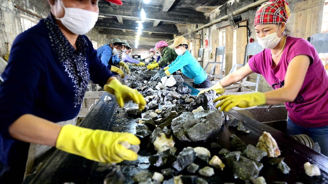 --FILE--Chinese workers check tungsten ore at a factory
