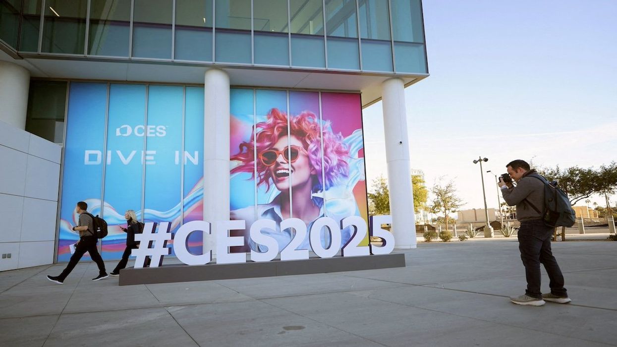 FILE PHOTO: A man takes a photo of a CES sign as setup continues for CES 2025, an annual consumer electronics trade show, in Las Vegas, Nevada, U.S. January 5, 2025.