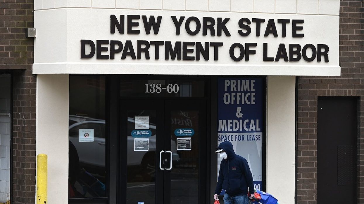FILE PHOTO: A man walks past the offices of the New York State Department of Labor in the Queens borough of New York City, NY, January 8, 2021.