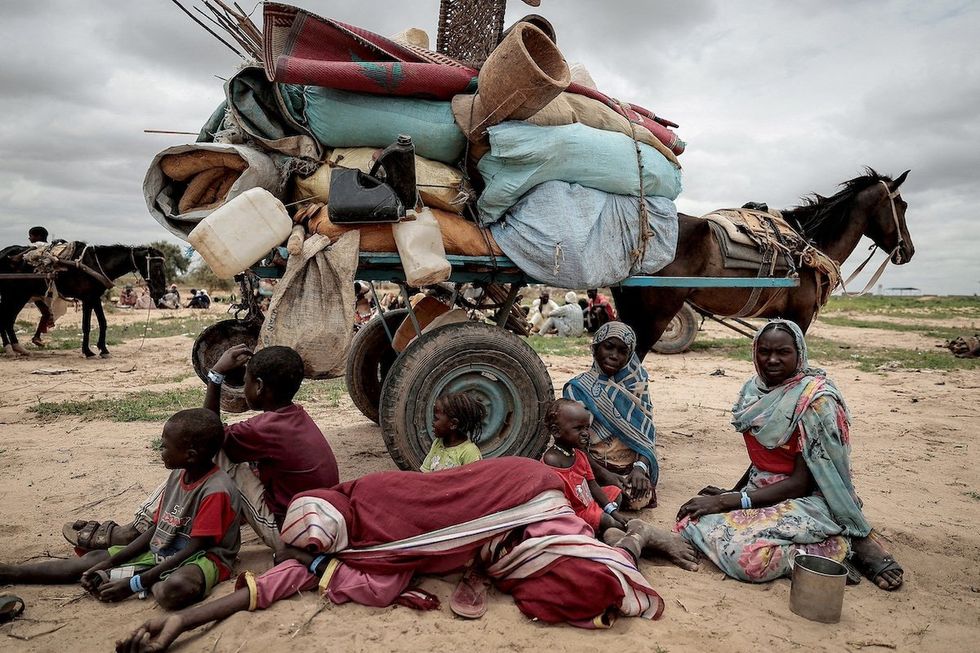 FILE PHOTO: A Sudanese family who fled the conflict in Murnei in Sudan's Darfur region, sit beside their belongings while waiting to be registered by UNHCR upon crossing the border between Sudan and Chad in Adre, Chad, July 26, 2023. 