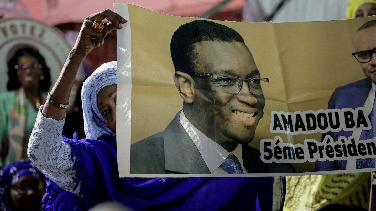 ​FILE PHOTO: A supporter of Senegalese presidential candidate Amadou Ba holds a poster during his campaign rally in Guediawaye on the outskirts of Dakar, Senegal March 10, 2024. 