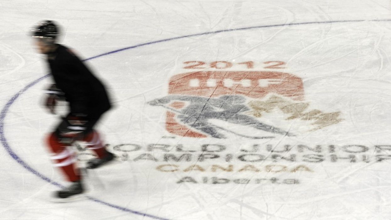FILE PHOTO: A Team Canada player skates past the tournament logo during practice in Edmonton December 25, 2011. Team Canada will play in the upcoming World Junior Hockey tournament in Calgary and Edmonton which takes place from December 26 to January 5, 2012.
