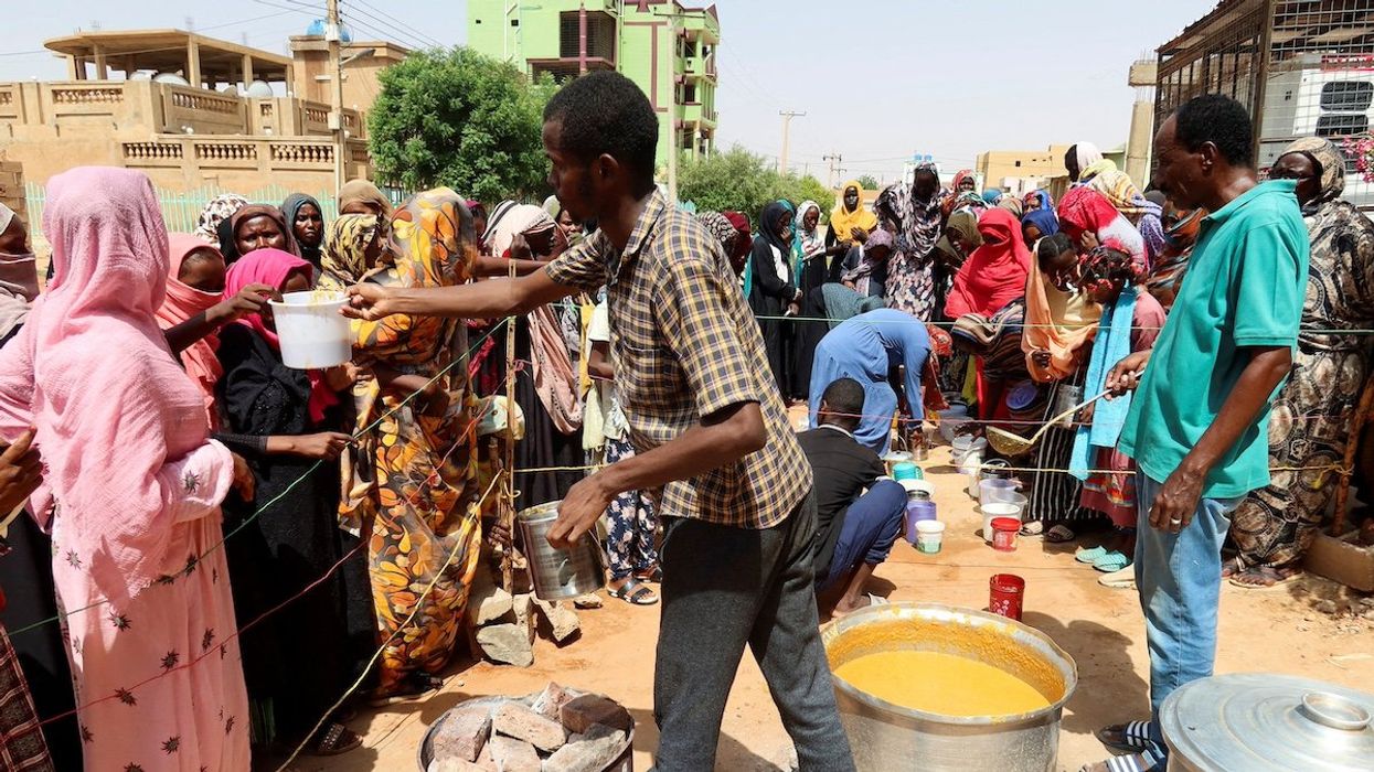 FILE PHOTO: A volunteer distributes food to people in Omdurman, Sudan, September 3, 2023.