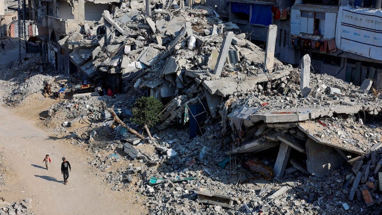 FILE PHOTO: Palestinian children walk past the rubble of houses, destroyed in previous Israeli strikes, amid the Israel-Hamas conflict, in Khan Younis, southern Gaza Strip, January 7, 2025.