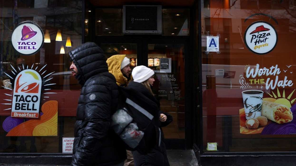 FILE PHOTO: People walk by a Taco Bell and Pizza Hut, subsidiaries of Yum! Brands, Inc. in Manhattan, New York City, U.S., February 7, 2022.