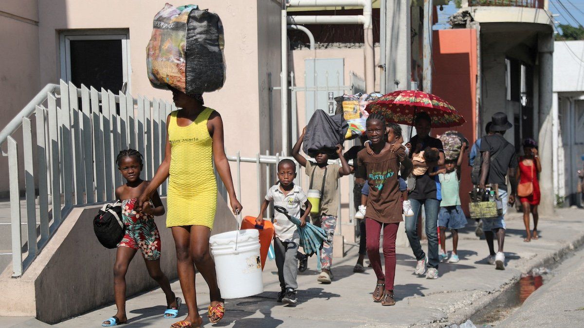 ​FILE PHOTO: People walk towards a shelter with their belongings fleeing from violence around their homes, in Port-au-Prince, Haiti March 9, 2024. 