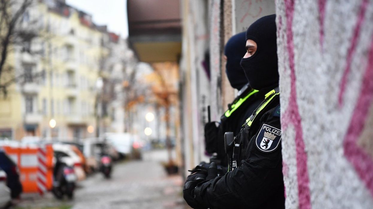 FILE PHOTO: Police officers stand at the entrance to a building during a raid in Berlin-Friedrichshain. Security forces have searched several properties in Berlin, Lower Saxony, North Rhine-Westphalia and Schleswig-Holstein in connection with the ban on the terrorist organization Hamas and the international network Samidoun in Germany.