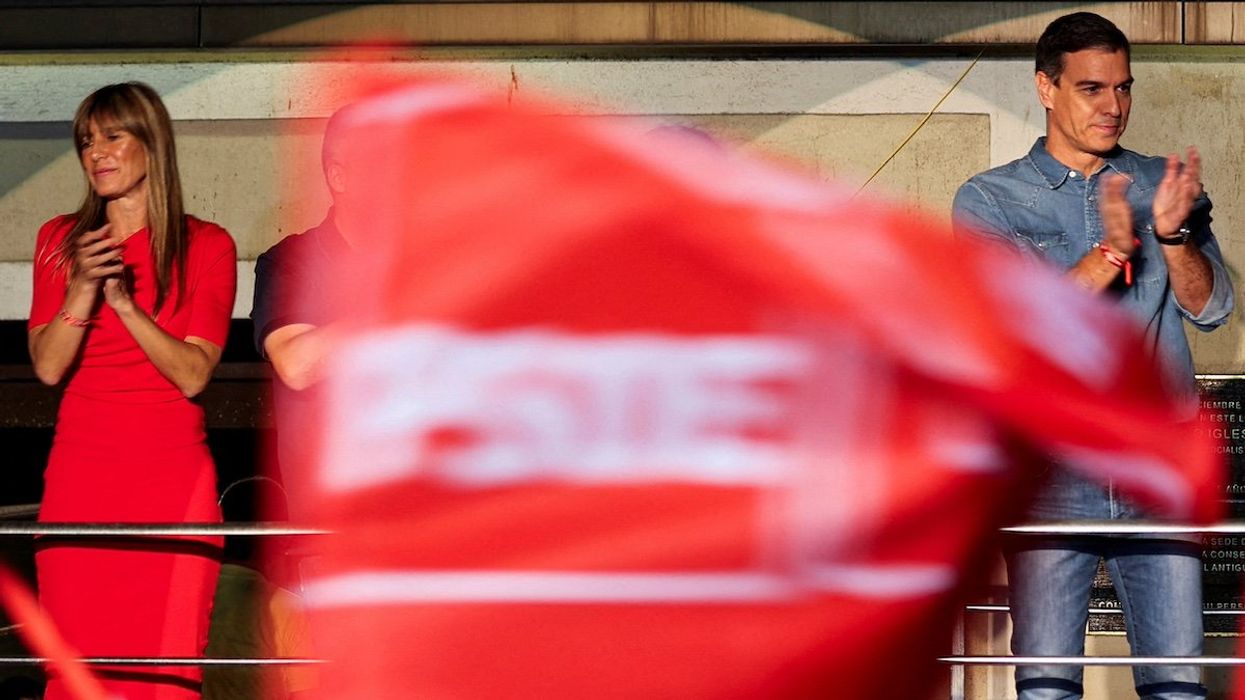 FILE PHOTO: Spain's Socialist leader and Prime Minister Pedro Sanchez, accompanied by his wife Begona Gomez, applauds as he addresses supporters during the general election, in Madrid, Spain, July 23, 2023.