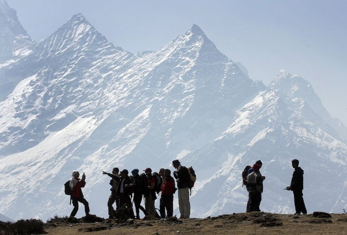 FILE PHOTO: Trekkers pause to admire Mt. Kusum Kangru (6369 mts) in the Mt. Everest region in Nepal March 30, 2006.