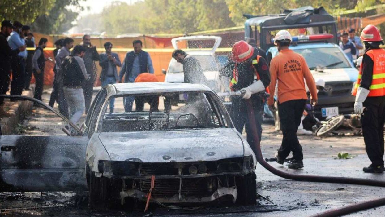 Firefighter douses a vehicle after a blast outside a court building in Islamabad, Pakistan November 11, 2025.