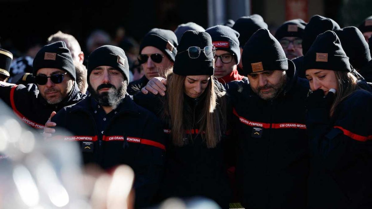 Firefighters and rescuers mourn next a makeshift memorial outside the "Le Constellation" bar in southwestern Switzerland, on January 4, 2026.