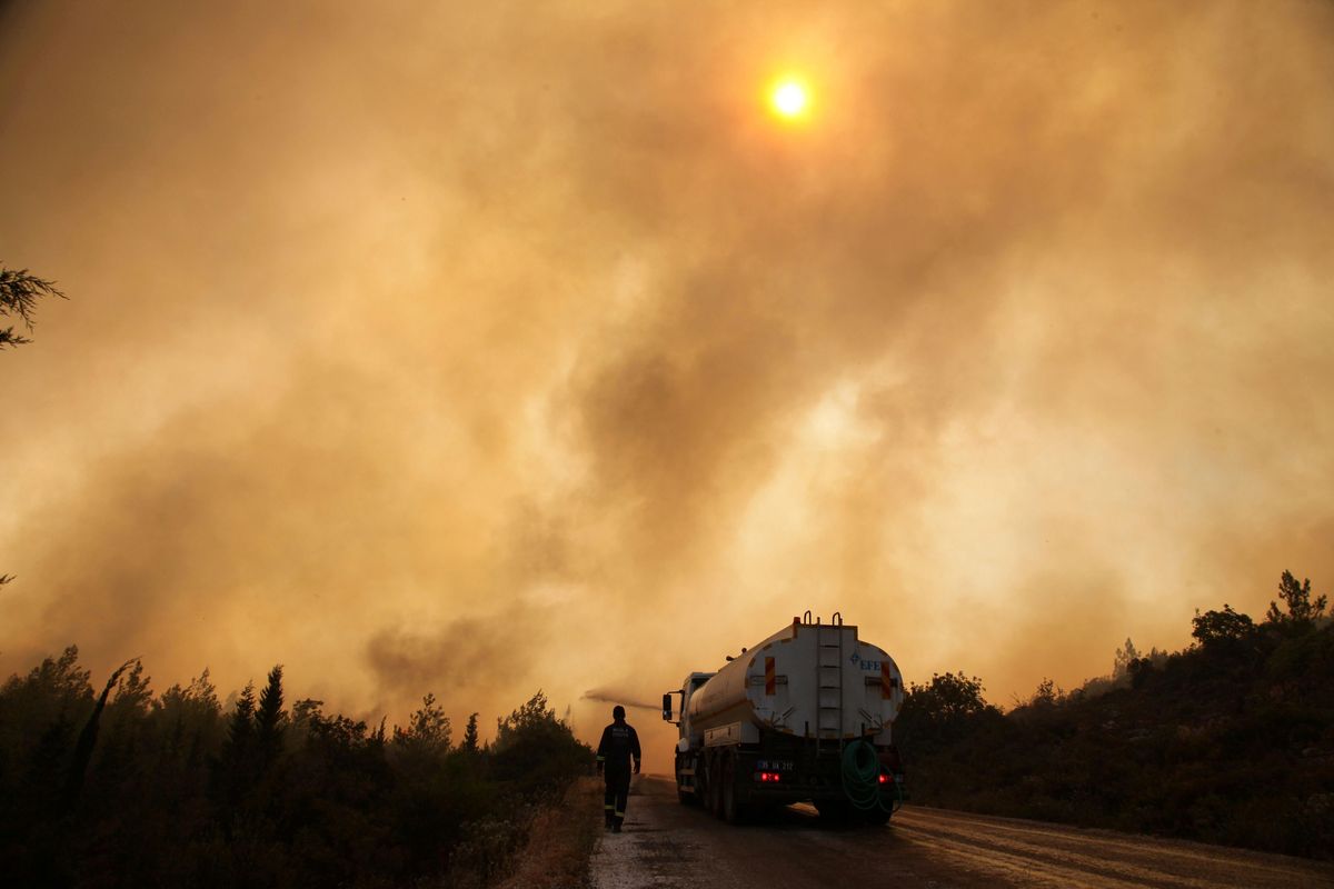Firefighters extinguish a wildfire in the Mazi region near Bodrum, Turkey, August 2, 2021.