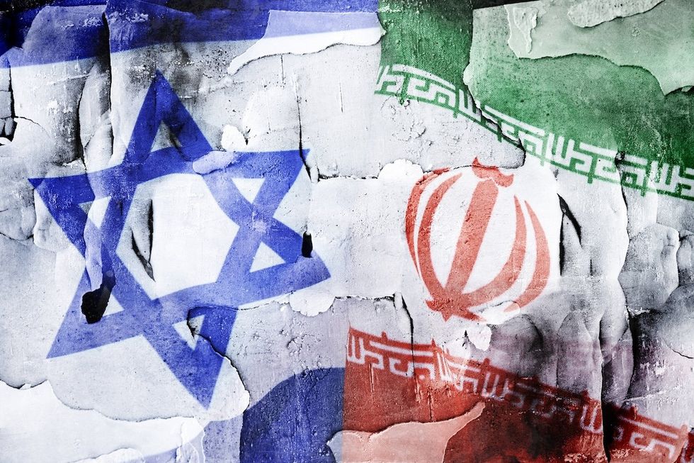 Flags of Israel and Iran on broken ground.