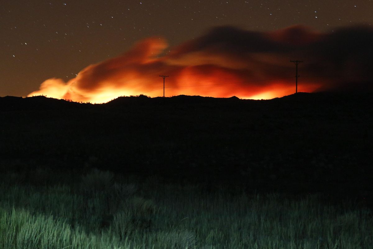 Flames illuminate the smoke rising from the Beckwourth complex fire. The Beckwourth Complex fire continues to burn through the night.