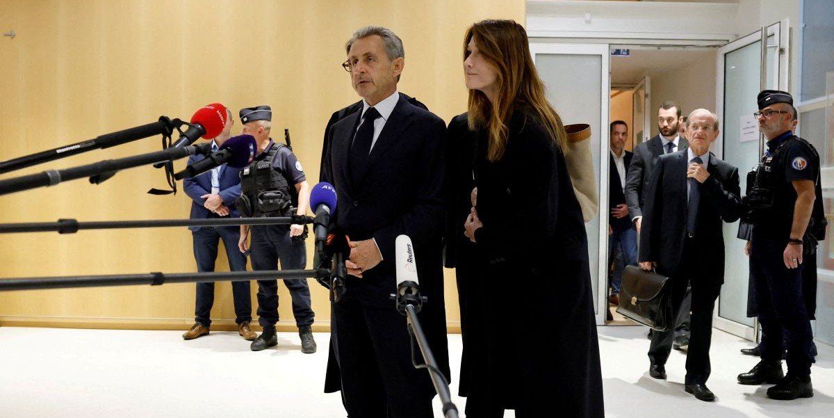 ​Former French President Nicolas Sarkozy talks to journalists, next to his wife Carla-Bruni Sarkozy and his lawyers, after the verdict in his trial with other defendants on charges of corruption and illegal financing of an election campaign related to alleged Libyan funding of his successful 2007 presidential bid, at the courthouse in Paris, France, September 25, 2025. 