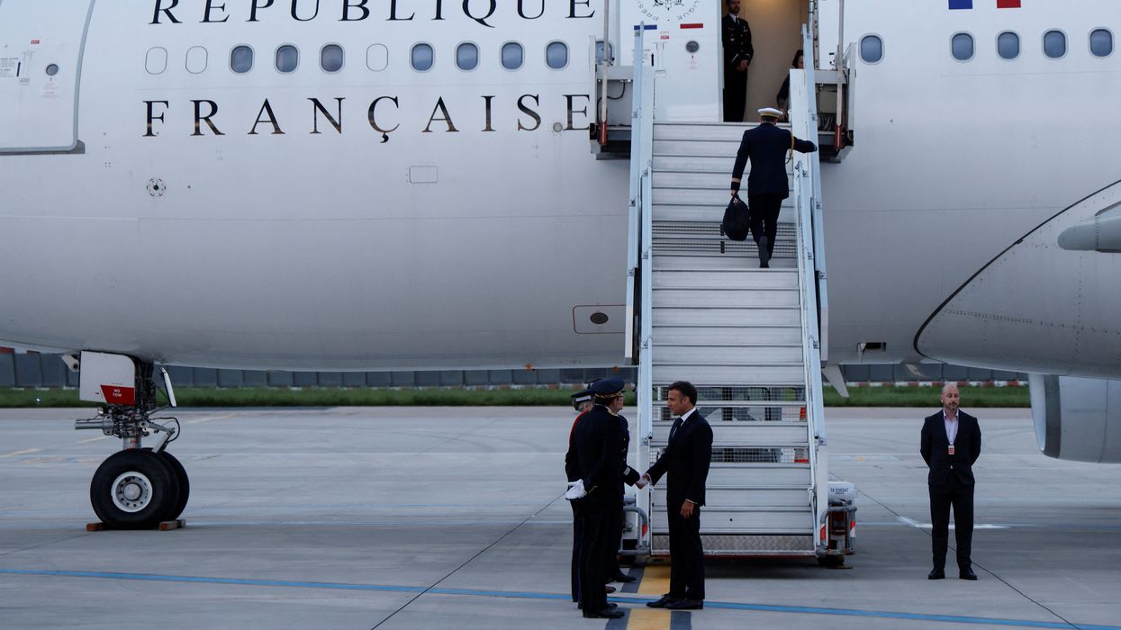 France's President Emmanuel Macron shakes hands with crew members before boarding his Presidential plane to travel to the Pacific archipelago of New Caledonia in an attempt to resolve a political crisis, at the Orly airport, a suburb of Paris on May 21, 2024.