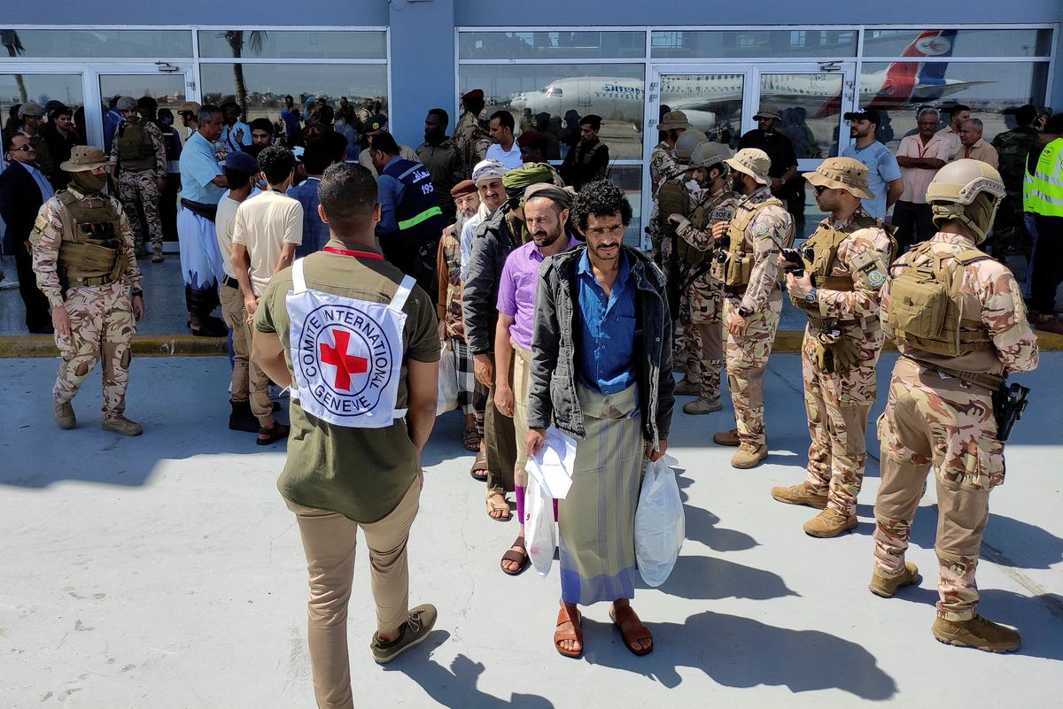 Freed Houthi prisoners stand as they wait to board an International Committee of the Red Cross (ICRC)-chartered plane at Aden Airport, in Aden, Yemen.