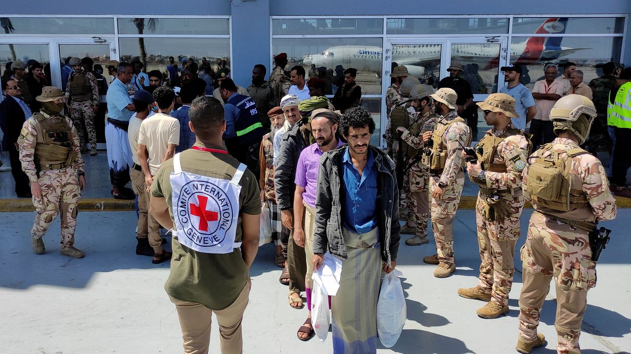 Freed Houthi prisoners stand as they wait to board an International Committee of the Red Cross (ICRC)-chartered plane at Aden Airport, in Aden, Yemen.