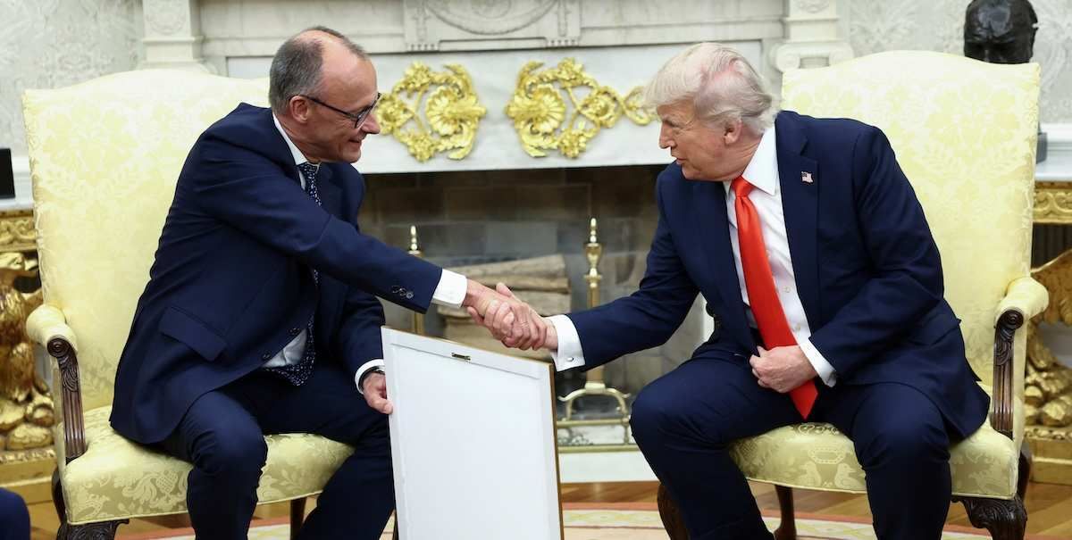 ​German Chancellor Friedrich Merz holds the framed birth certificate of U.S. President Donald Trump's grandfather as Merz and Trump shake hands during a meeting at the White House in Washington, D.C., U.S., June 5, 2025. 