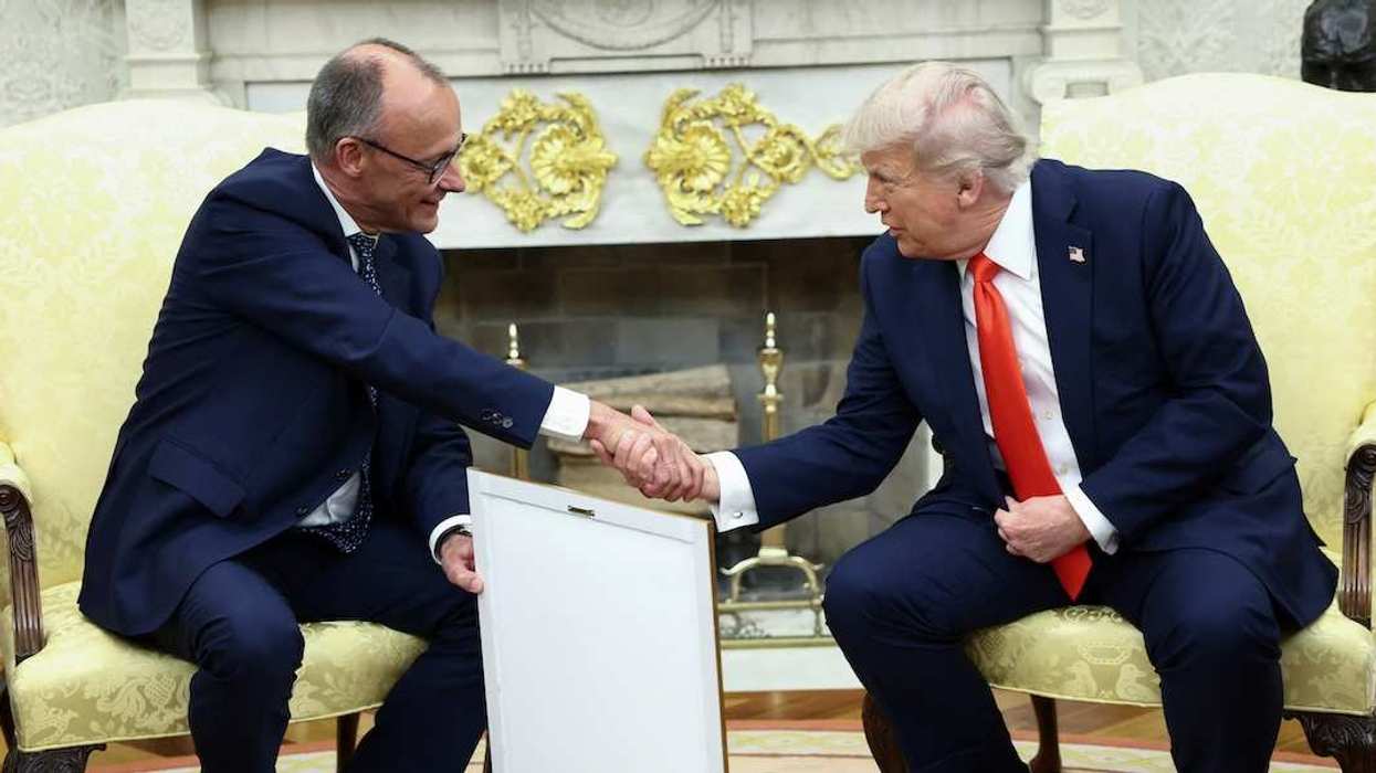 German Chancellor Friedrich Merz holds the framed birth certificate of U.S. President Donald Trump's grandfather as Merz and Trump shake hands during a meeting at the White House in Washington, D.C., U.S., June 5, 2025.