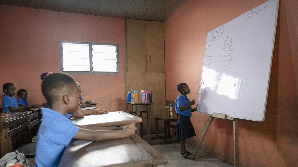Ghana, Accra, 2023-02-16. Young schoolchildren in uniform learning multiplication tables. Illustration image of children in a school in Ghana. A little girl is at the blackboard reciting in front of the class. 