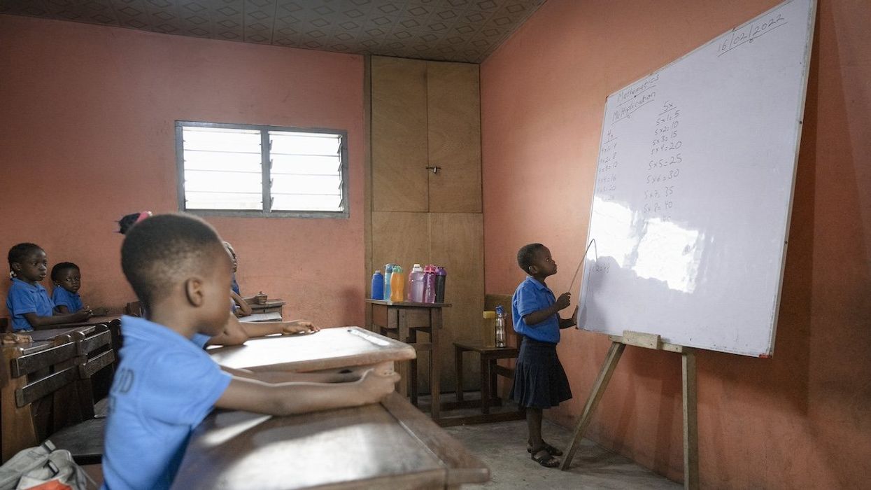Ghana, Accra, 2023-02-16. Young schoolchildren in uniform learning multiplication tables. Illustration image of children in a school in Ghana. A little girl is at the blackboard reciting in front of the class.
