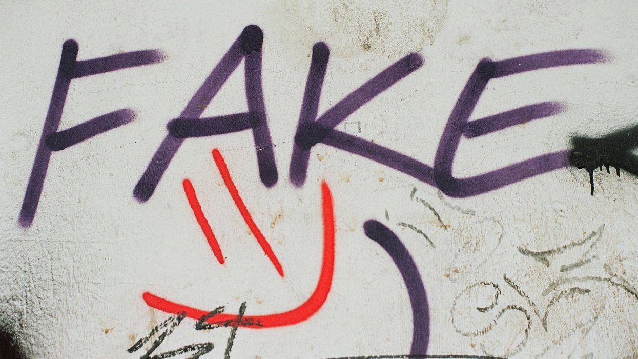 Graffiti on a wall that says "fake."