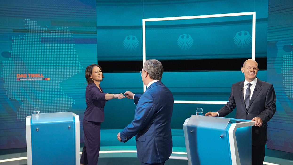 hairwoman of Buendnis 90/Die Gruenen Annalena Baerbock is greeted by Prime Minister of North Rhine-Westphalia (NRW) and leader of the Christian Democratic Union (CDU) Armin Laschet as German Finance Minister and Social Democratic Party candidate Olaf Scholz looks on before the start of a televised debate of the candidates to succeed Angela Merkel as German chancellor in Berlin, Germany, August 29, 2021