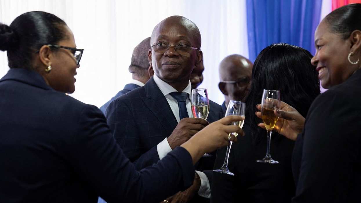 Haiti's new interim Prime Minister Michel Patrick Boisvert holds a glass with a drink after a transitional council took power with the aim of returning stability to the country, where gang violence has caused chaos and misery, on the outskirts of Port-au-Prince, Haiti April 25, 2024.