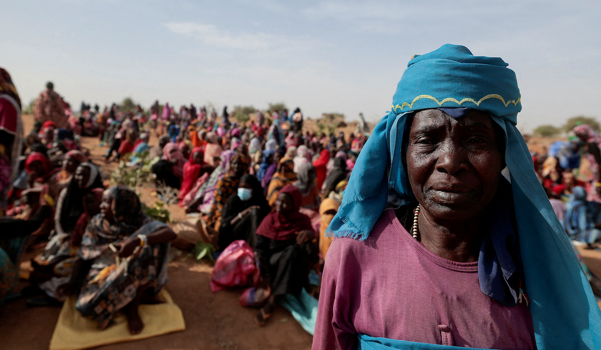 ​Halime Adam Moussa, a Sudanese refugee who is seeking refuge in Chad for a second time, waits with other refugees to receive a food portion from an international aid agency near the border between Sudan and Chad in Koufroun, Chad, May 9, 2023.