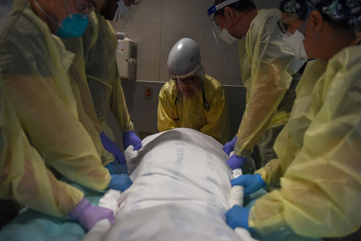 Healthcare personnel prepare to rotate a patient who is on a ventilator inside a room for patients with the coronavirus disease (COVID-19) at a hospital in Hutchinson, Kansas, U.S., November 20, 2020.