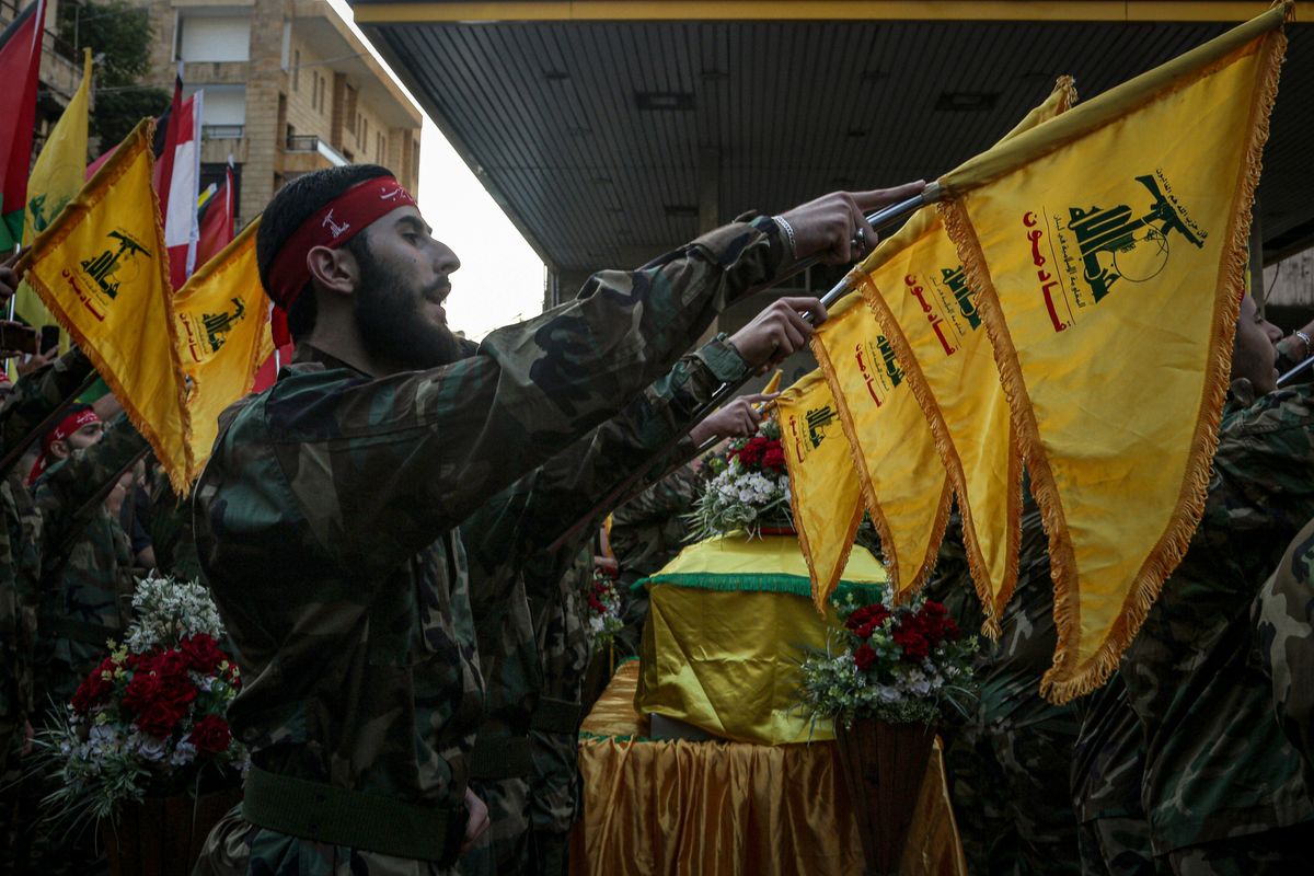 Hezbollah militants take an oath as they stand near the coffin of their colleague who was killed in clashes with Israeli soldiers in south Lebanon