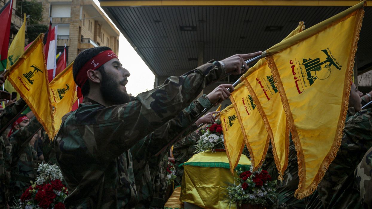 Hezbollah militants take an oath as they stand near the coffin of their colleague who was killed in clashes with Israeli soldiers in south Lebanon