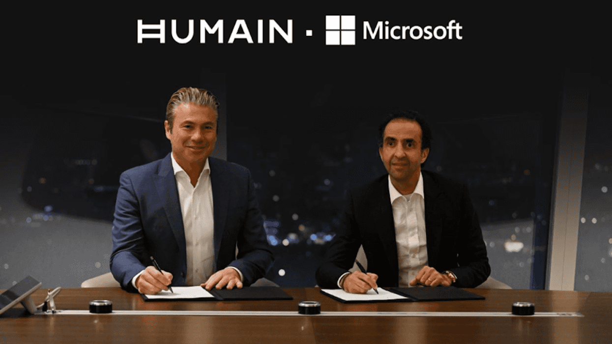 Humain . Microsoft logo with two people writing at a desk