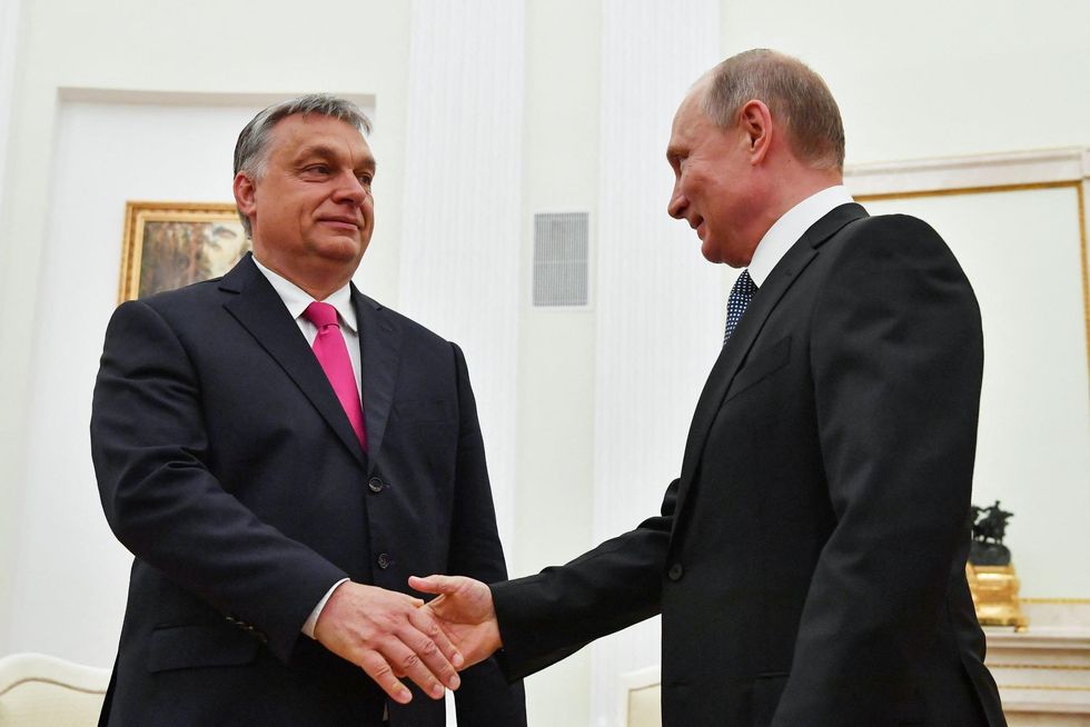 Hungary's Prime Minister Viktor Orban shakes hands with Russian President Vladimir Putin. 