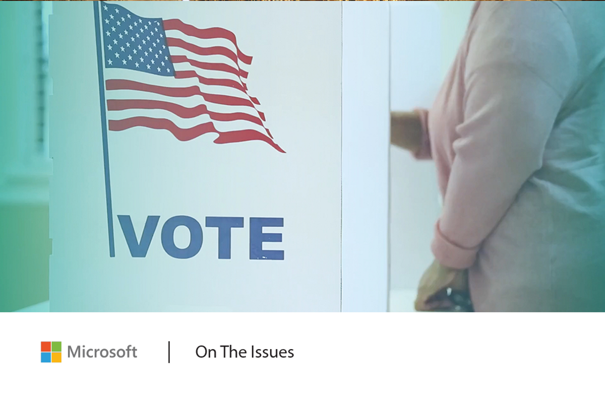 Image of a person voting at a voting booth decorated with an American flag