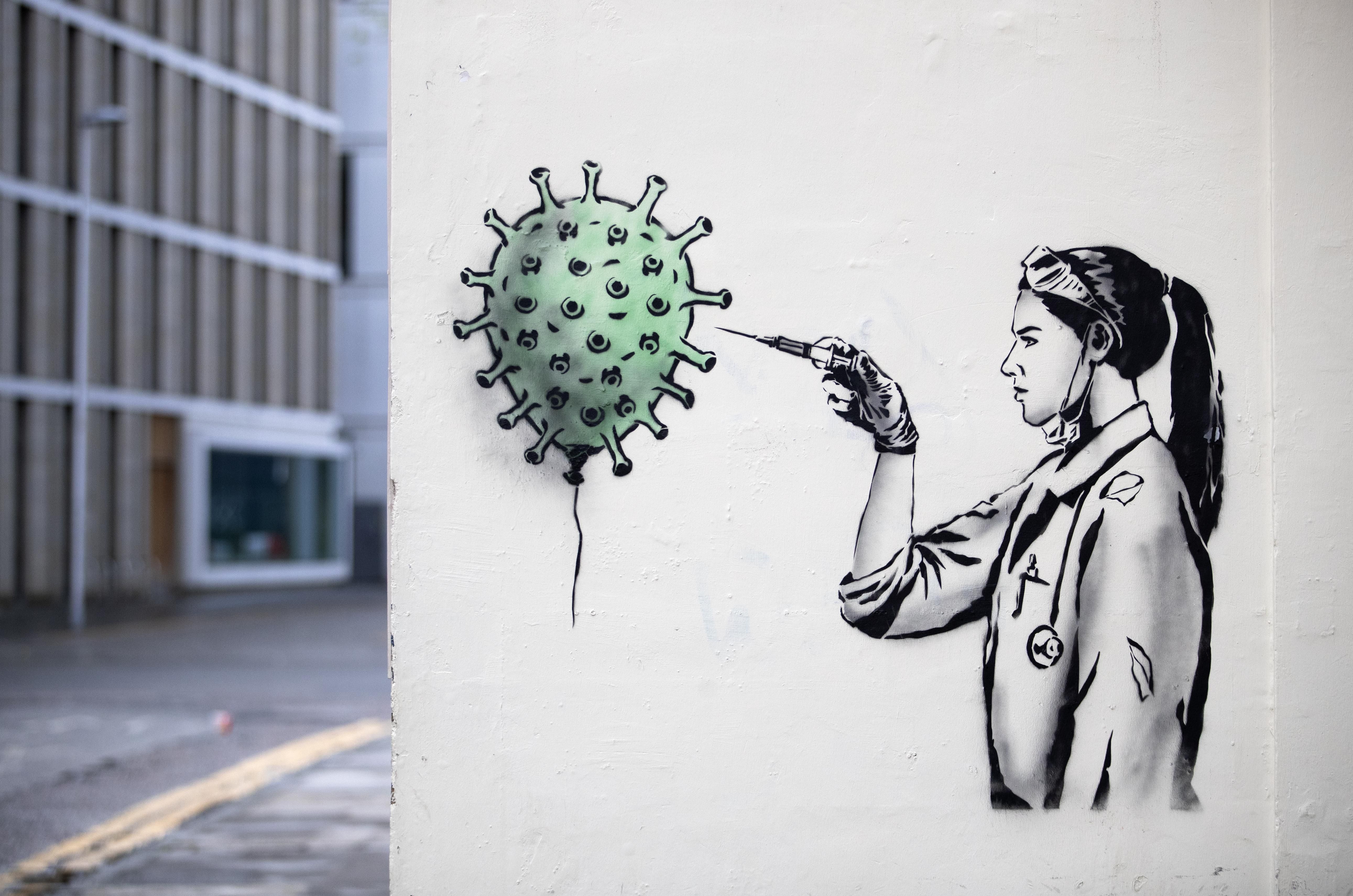 Wall art depicting a doctor injecting vaccine into a COVID cell 