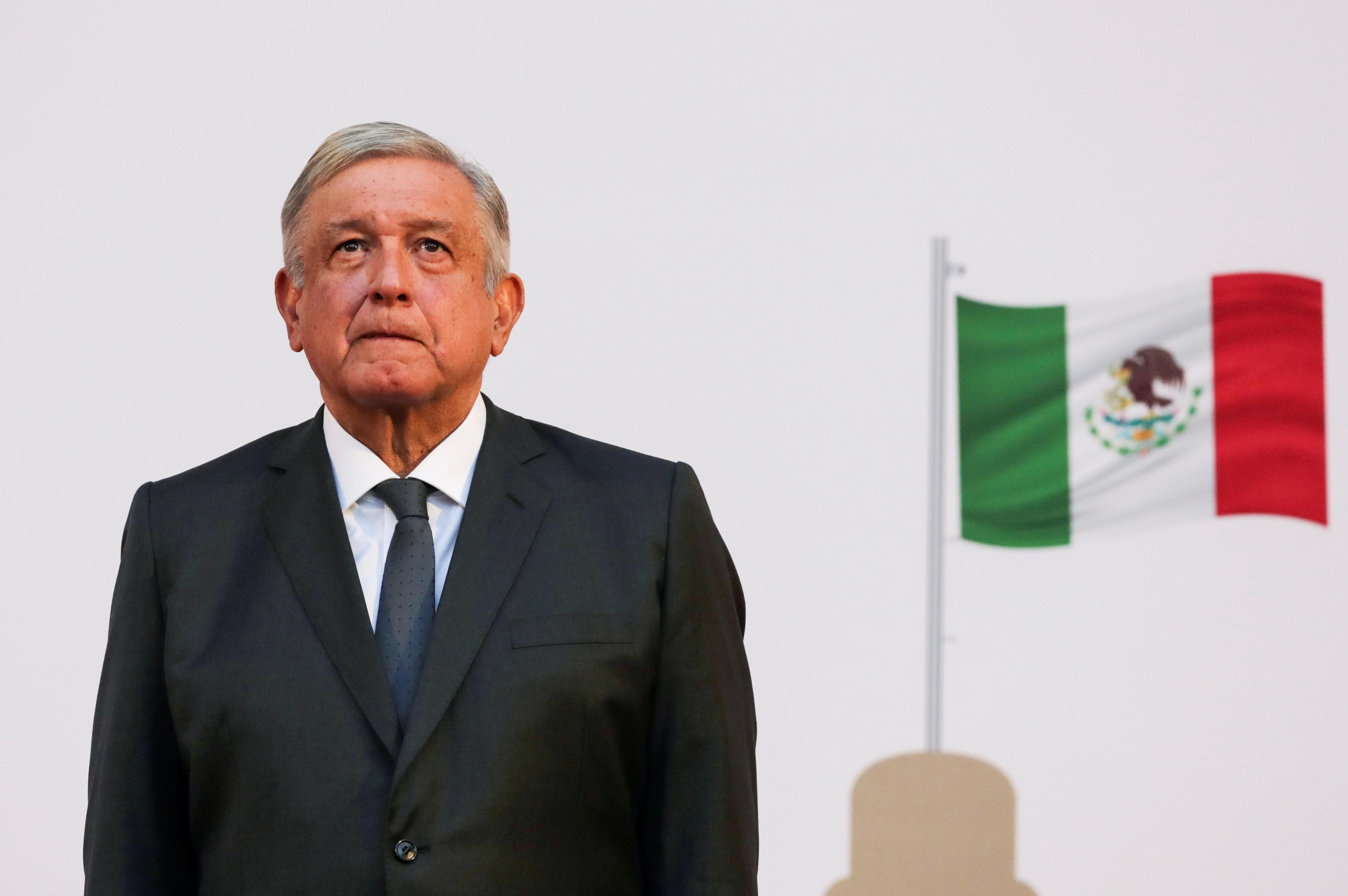Mexico's president, Andres Manuel Lopez Obrador, listens to the national anthem after addressing the nation on his second anniversary as the President of Mexico, at the National Palace in Mexico City, Mexico, December 1, 2020.