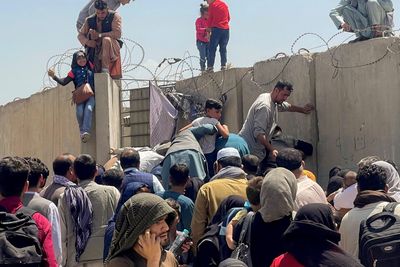 A man pulls a girl to get inside Hamid Karzai International Airport in Kabul, Afghanistan August 16, 2021.