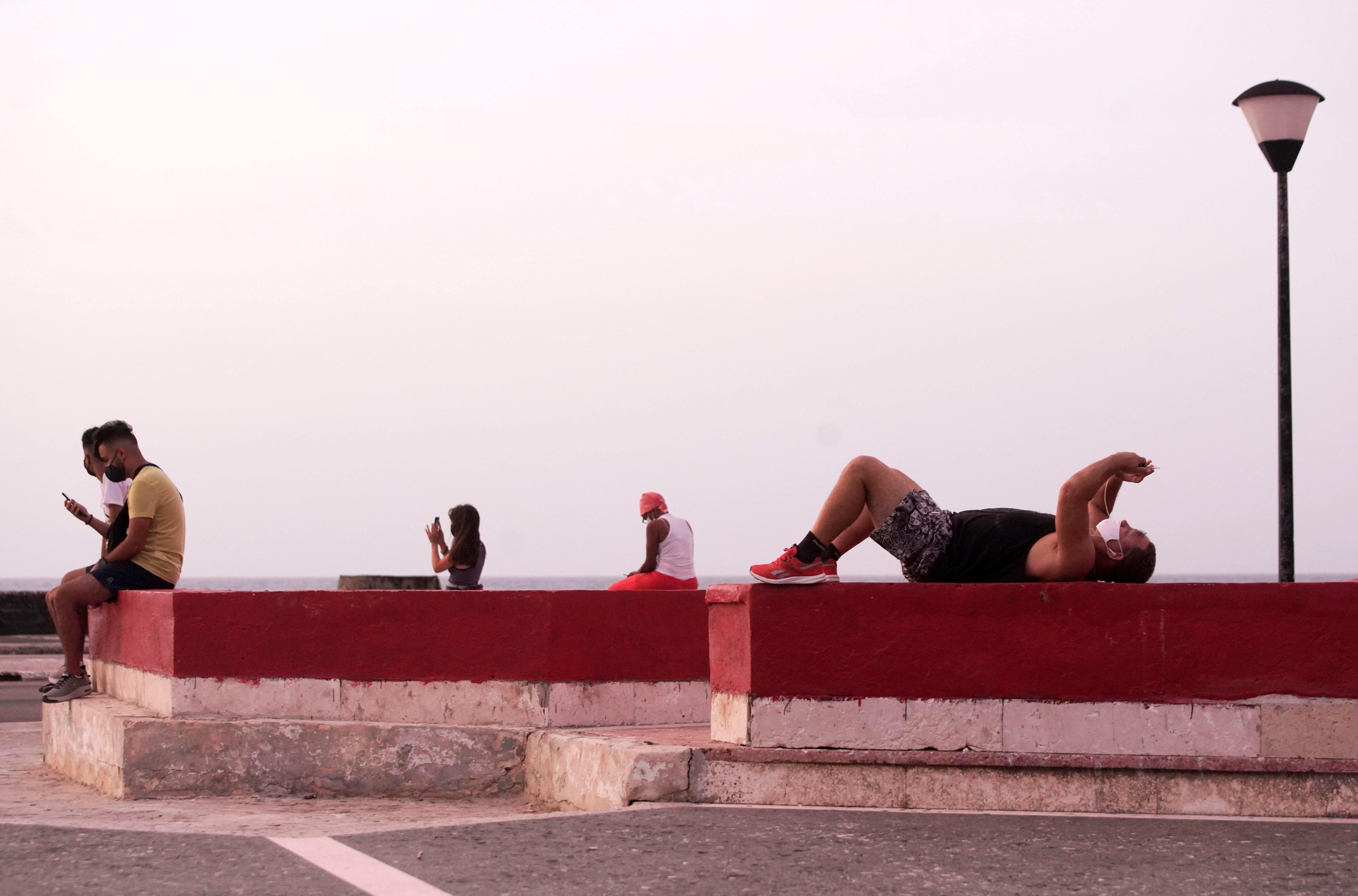 People connect to the internet at a public hotspot in Havana, Cuba, August 18, 2021