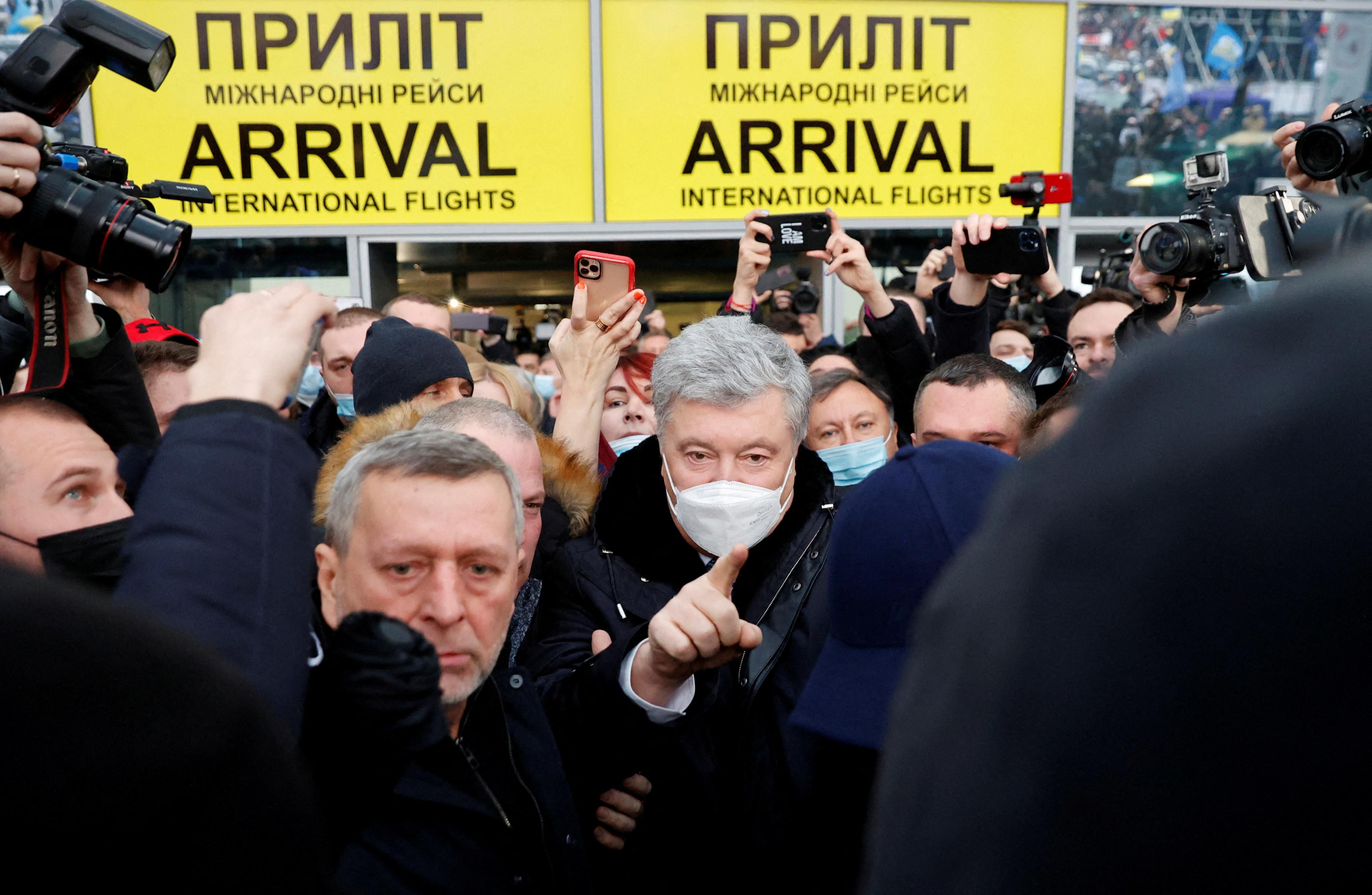 Ukrainian former President Petro Poroshenko gestures as he walks to address supporters upon arrival at Zhulyany airport in Kyiv, Ukraine January 17, 2022.