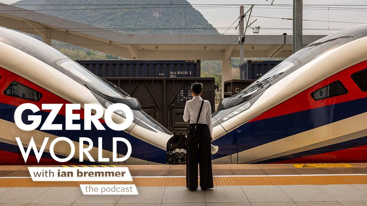 A woman in China standing in front of two high-speed trains with the GZERO World Podcast logo superimposed on top.
